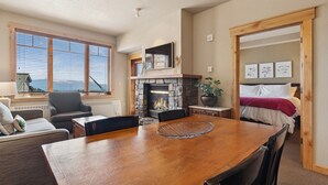 A cozy room with a fireplace, a dining table, a sofa, and a bed.