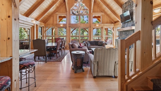 Un intérieur spacieux en bois, avec de hauts plafonds, de grandes fenêtres et une cheminée.