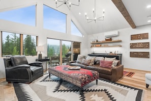 A spacious living room with a large window, a fireplace, and a dining area.
