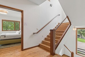 A staircase with wooden steps and a handrail, leading to an upper floor.