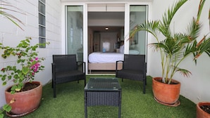 A small patio area with two wicker chairs, a glass table, and potted plants. - w* | Fascinating loft with Spectacular Ocean View (Máncora)