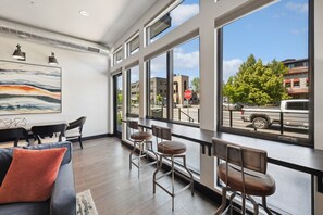 Un intérieur moderne avec de grandes fenêtres, un espace bar et un coin salon.