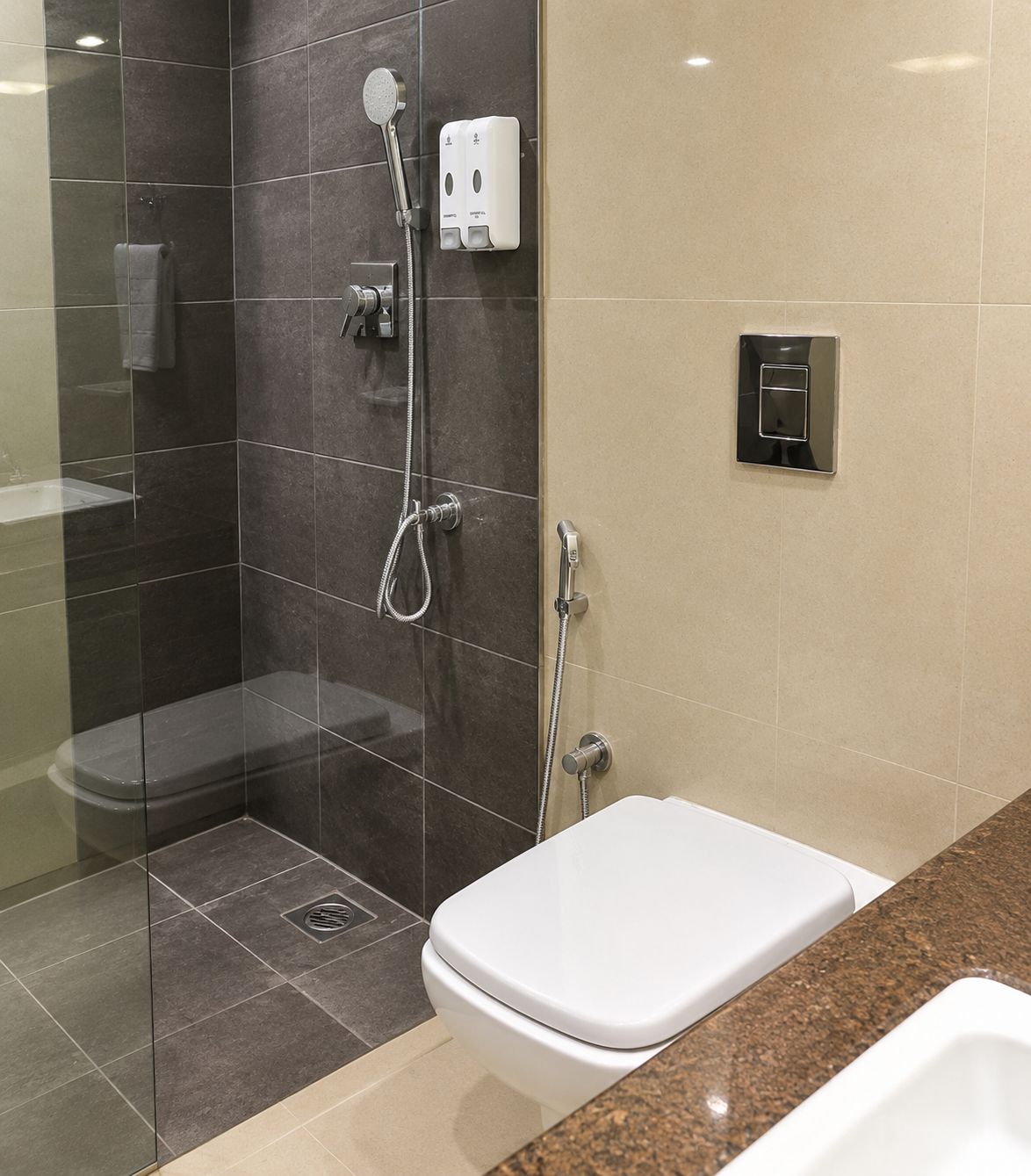 A modern bathroom with a glass-enclosed shower, a white toilet, and a granite countertop.