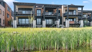 A modern multi-story residential building with balconies and large windows. - Ski Room | Mountain Views | Hot Tub (Whitefish)
