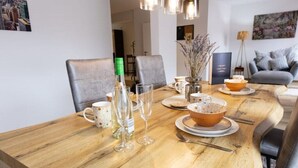 A dining table set with plates, bowls, glasses, and cutlery, surrounded by chairs. - Traumhafte Stadtwohnung (Duisburg)