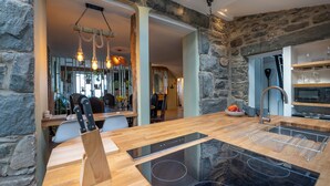 Eine moderne Küche mit Steinwand, Holz Arbeitsplatte und eingebauten Geräten.