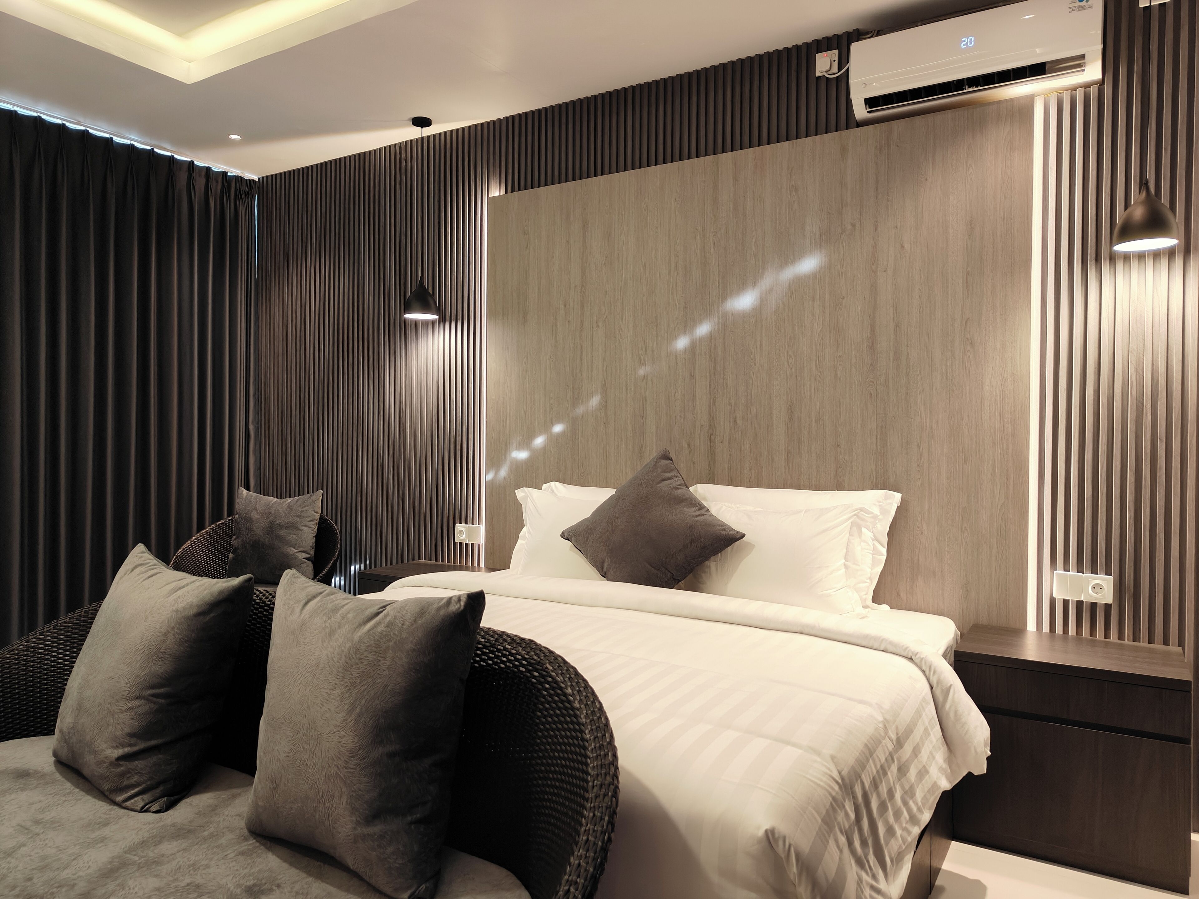 A modern bedroom with a bed, pillows, and a nightstand.