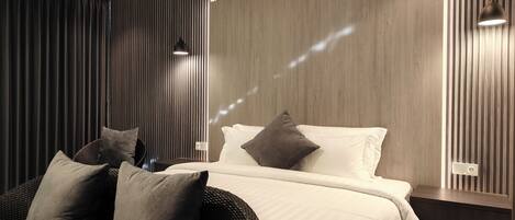 A modern bedroom with a bed, pillows, and a nightstand.