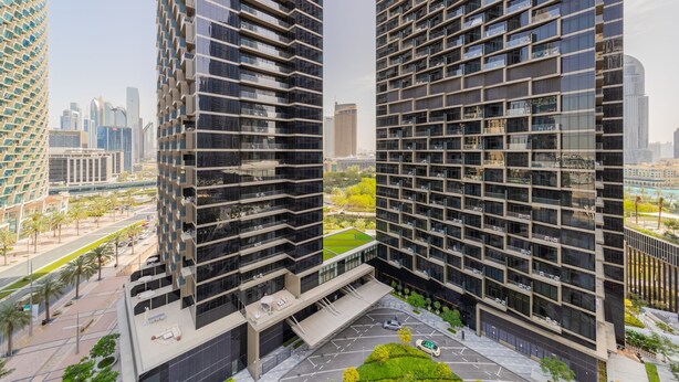 Ein modernes Hochhaus mit einem einzigartigen Fassadendesign, das ein Raster aus Fenstern und Balkonen zeigt.