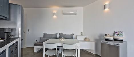 A modern kitchen with a dining table, chairs, a refrigerator, and a built-in oven.