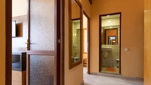A hallway leading to a bathroom with a sink and toilet visible through a glass door. - HOTEL DELTA (Constanta)