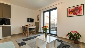 A modern apartment with a kitchen, dining area, and a large window. - Apartments Sky (Trogir)