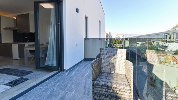 A modern apartment with a balcony, a kitchen, and a dining area. - Apartments Sky (Trogir)