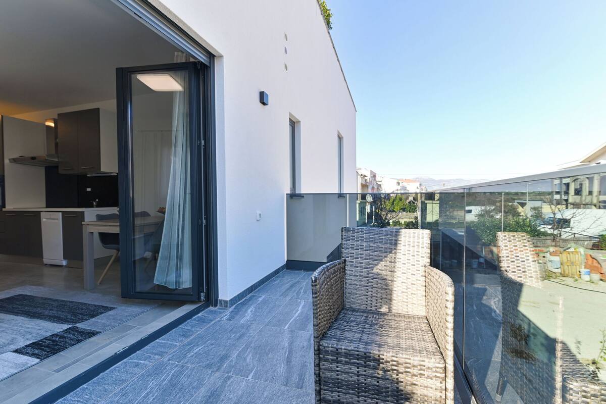 A modern apartment with a balcony, a kitchen, and a dining area.