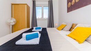 A hotel room with a bed, two bedside tables, a wall-mounted artwork, a window with curtains, and a door. - Apartment Mario (Okrug Gornji)