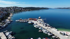 A marina with boats docked, a pier, and a building with a red roof. - Apartment Mario (Okrug Gornji)