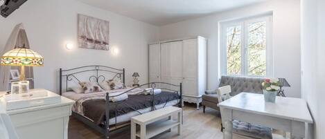 Camera da letto con un letto, comodino, lampada, armadio e finestra vista.