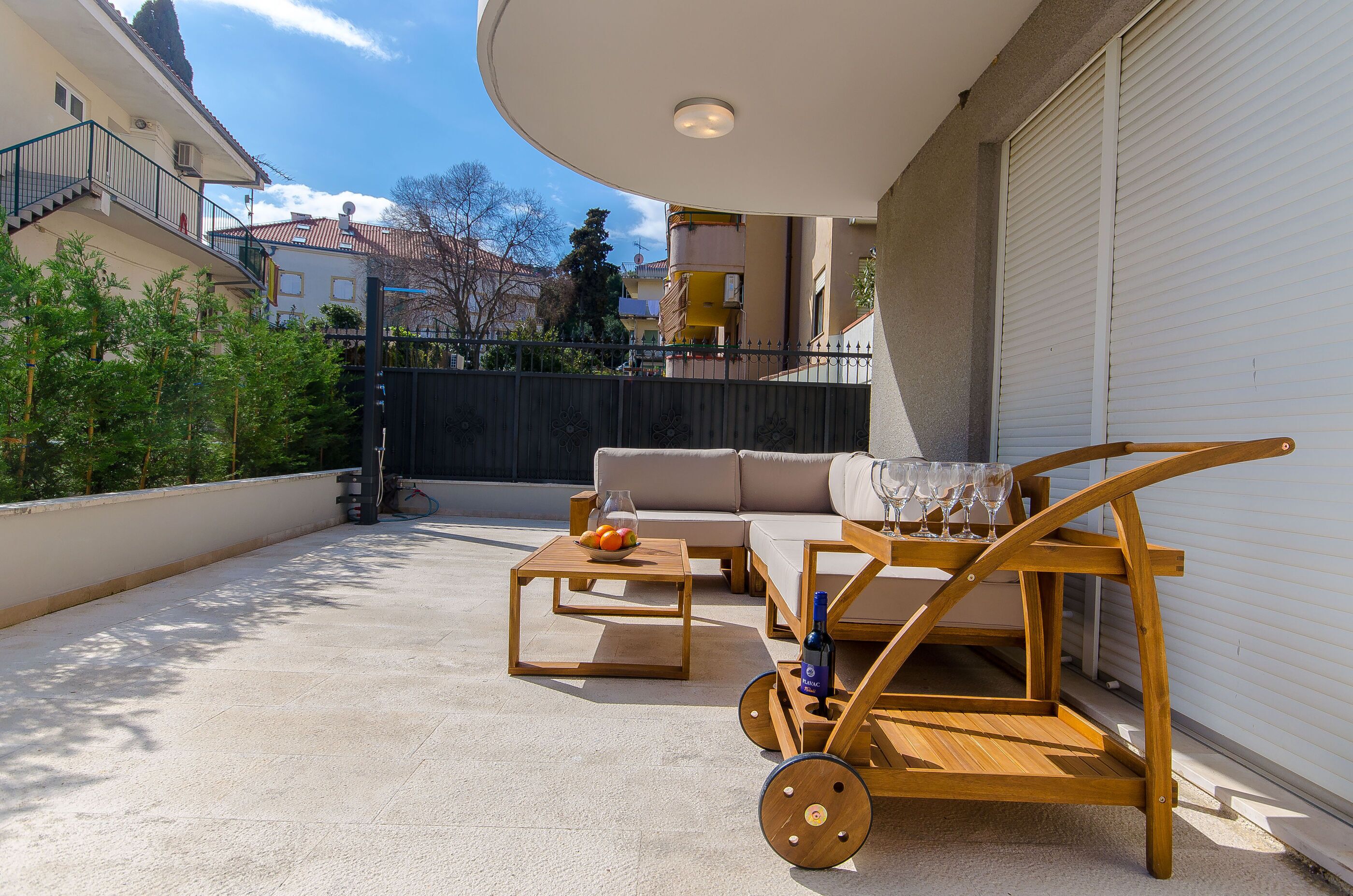 Eine Dachterrasse mit einem Holztisch, einer Couch und einem Weinkwagen.