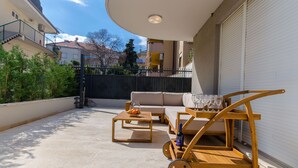 A rooftop terrace with a wooden table, a sofa, and a wine cart. - Apartment Gilda Lux (Split)