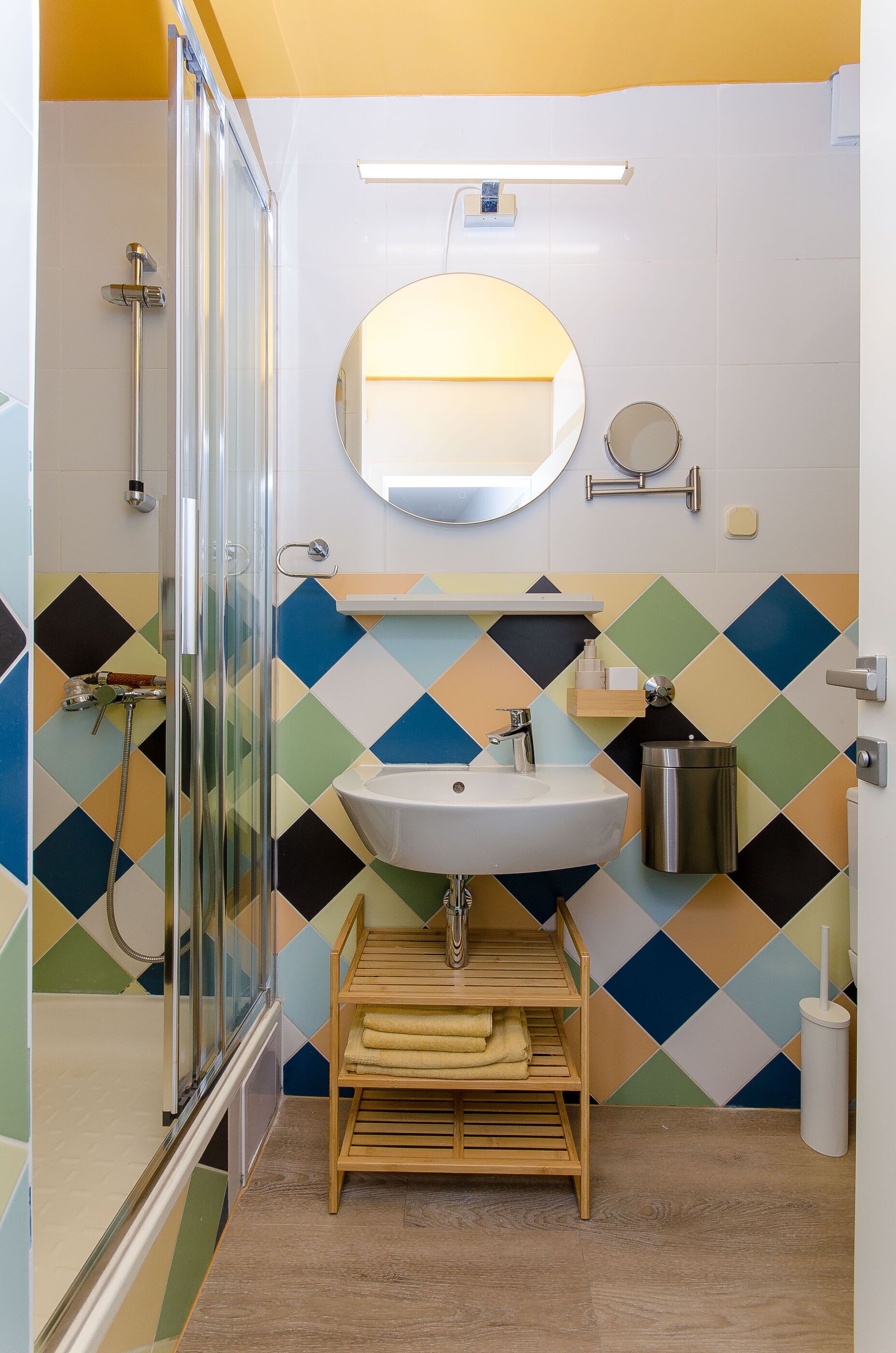 A bathroom with a shower, sink, and mirror.