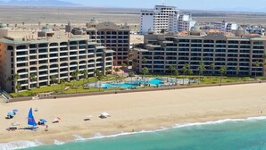 Un complexe hôtelier comprenant plusieurs bâtiments, une piscine et une plage.