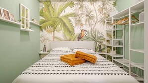A bedroom with a bed, a wardrobe, and a shelf with pictures. - Vita Lenta Pigneto: your apartment with terrace and jacuzzi in the heart of Rome (Roma)