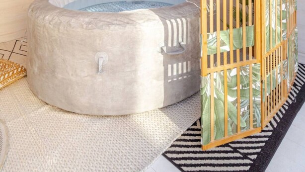 A hot tub under a thatched roof, surrounded by bamboo walls and a tropical plant. - Vita Lenta Pigneto: your apartment with terrace and jacuzzi in the heart of Rome (Roma)