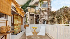 A balcony with two white chairs and a small yellow table, surrounded by a white railing. - Vita Lenta Pigneto: your apartment with terrace and jacuzzi in the heart of Rome (Roma)