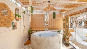 A spa area with a hot tub, bamboo ceiling, and decorative wall elements. - Vita Lenta Pigneto: your apartment with terrace and jacuzzi in the heart of Rome (Roma)