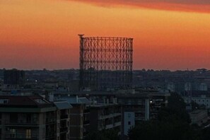 A cityscape at dusk with a prominent metal structure in the center.