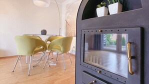 Moderni keittiö, jossa on sisäänrakennettu uuni, ruokailutila, jossa on keltaiset tuolit, ja riippuvalaisin.
