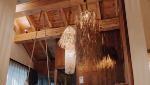 Un intérieur en bois avec un espace salon suspendu et un luminaire suspendu.
