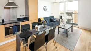 Un appartement moderne comprenant une cuisine, un coin repas et un salon.