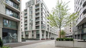 Un immeuble résidentiel moderne à plusieurs étages, doté de balcons, de grandes fenêtres et d’un design urbain épuré.
