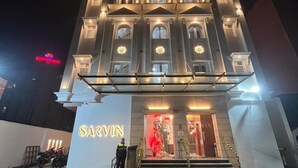 A building with a prominent "SARVIN" sign at the entrance, featuring a grand facade with multiple windows and a staircase leading up to the main doors. - Hotel Sarvin (Lucknow)