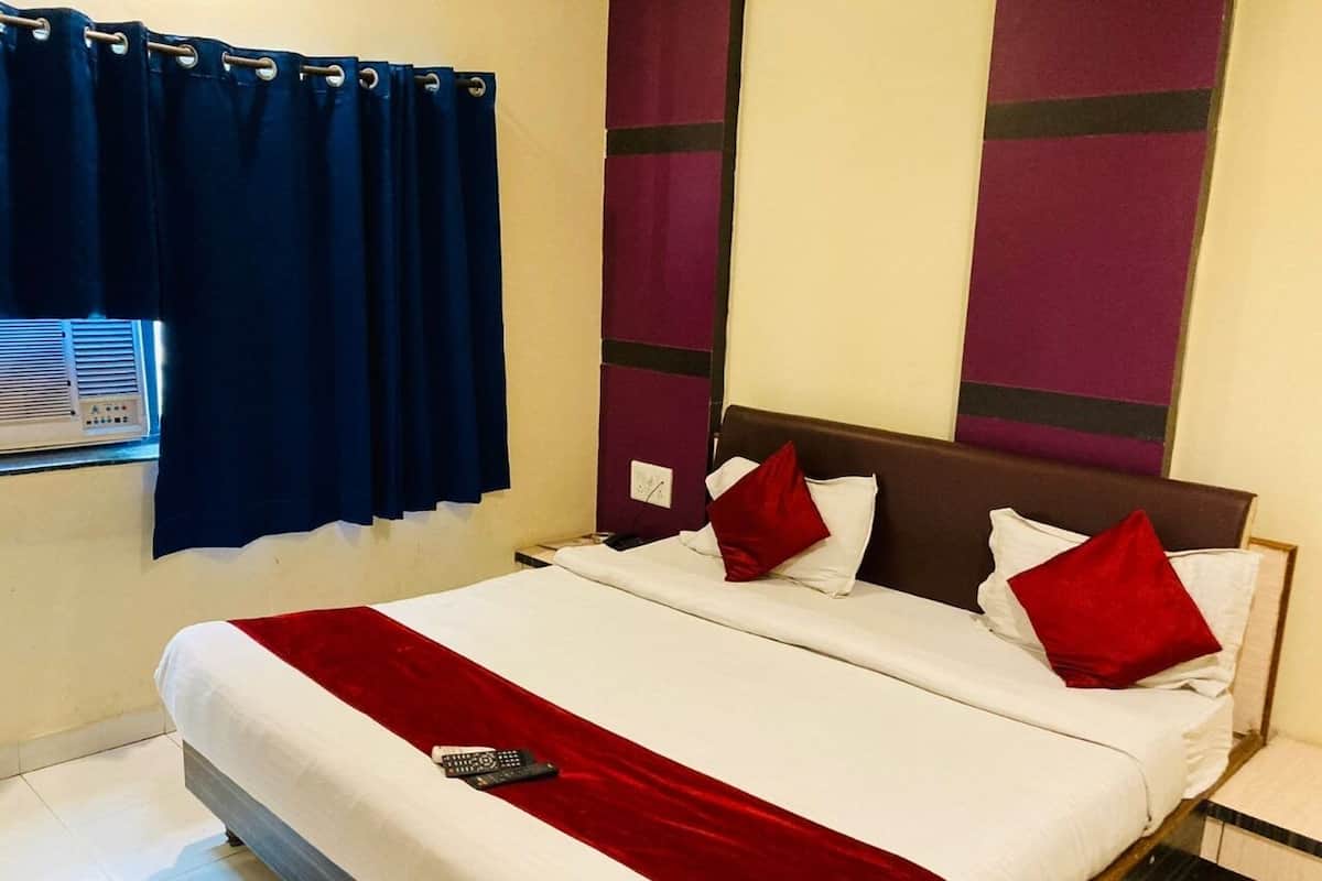Una habitación de hotel con una cama grande, una ventana con cortinas y una pared con diseño geométrico.