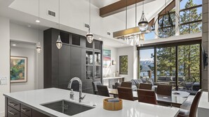 A modern kitchen with a large island, dark cabinetry, and pendant lighting. - 305A Boulder | 4BR/4BA Crystal Bay Lake View (Crystal Bay)