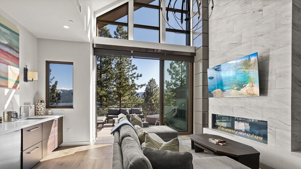 A modern living area with a sofa, coffee table, and a TV mounted on the wall. - 305A Boulder | 4BR/4BA Crystal Bay Lake View (Crystal Bay)