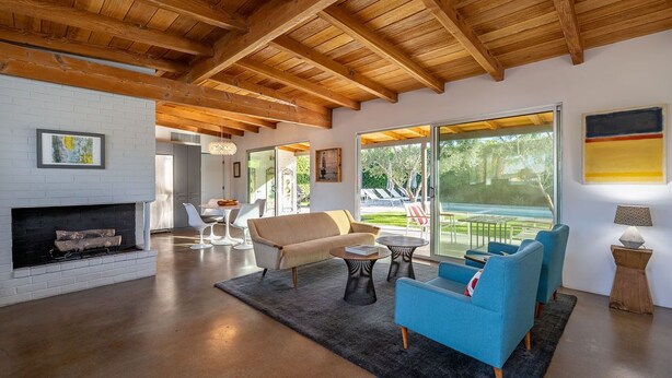 A spacious living room with a fireplace, modern furniture, and large windows offering a view of the outdoors. - Modern Olive 3  Mid Century Modern Retreat (Palm Springs)