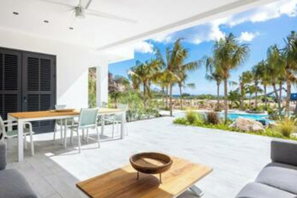 A modern outdoor seating area with a pool and palm trees.