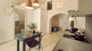 Une cuisine spacieuse avec un coin repas, des murs en pierre et des luminaires suspendus.