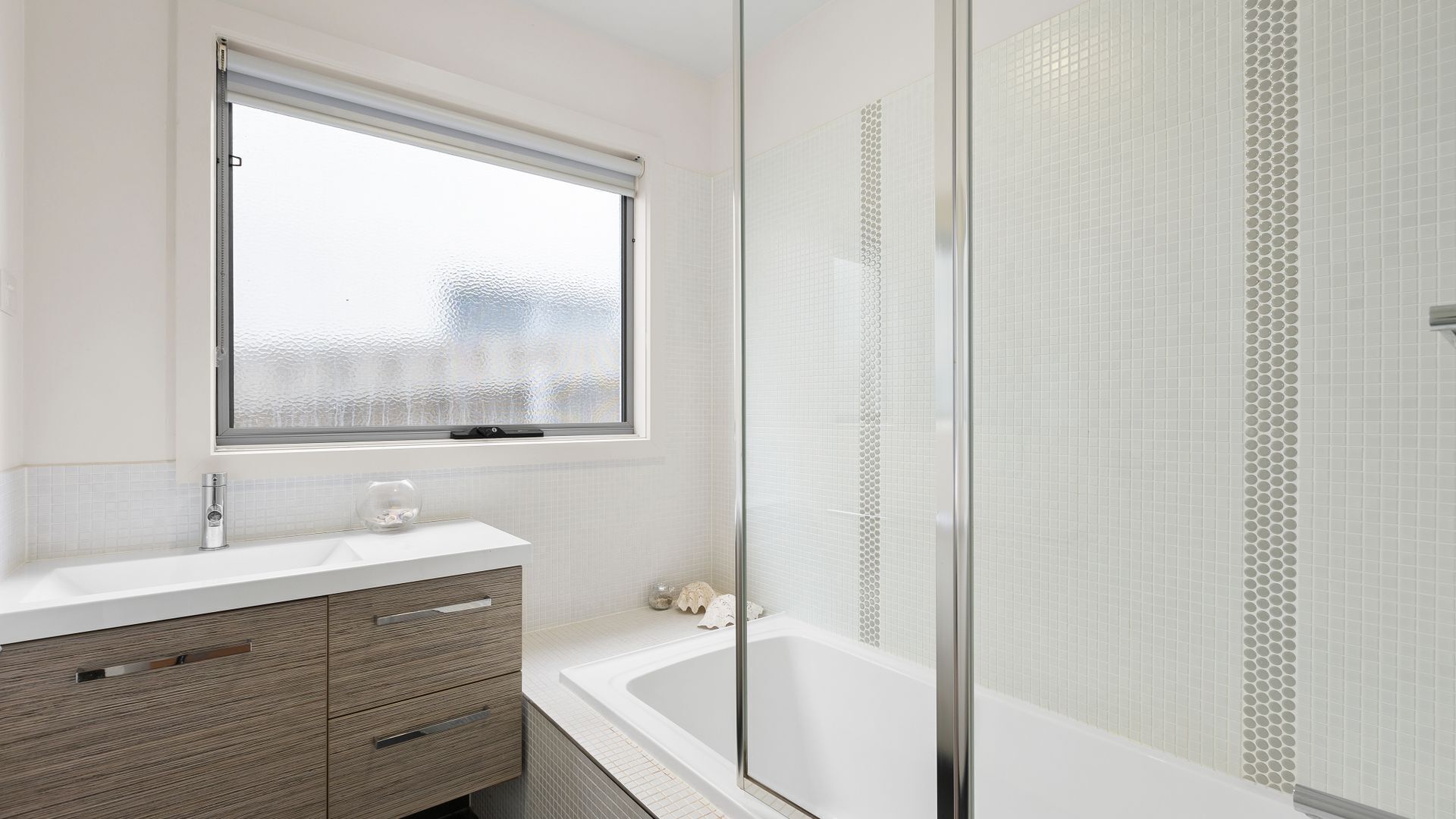 Ein Badezimmer mit Badewanne, Duschkabine, Waschtisch und Spiegel sowie einem Fenster.