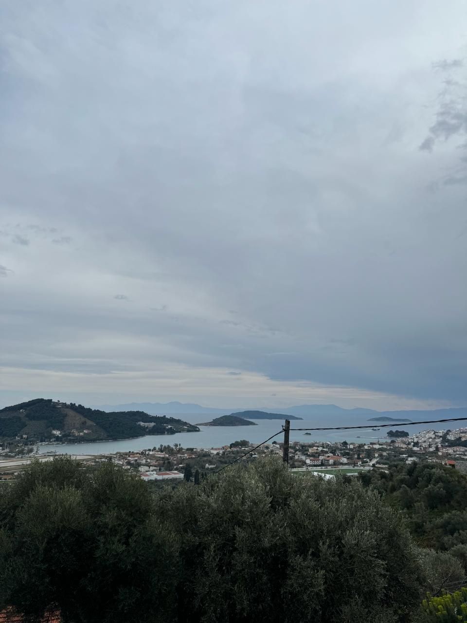 A coastal town with a view of the sea and hills in the background.