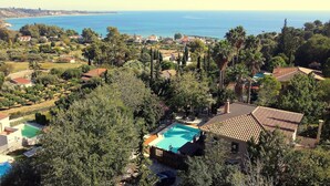 A residential area with a swimming pool surrounded by trees and houses. - Okeanis Apartments & Suites Adults Only (Kefalonia)