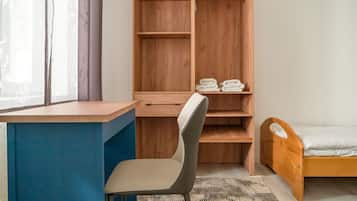 A bedroom with a wooden bed, a desk, and a chair.