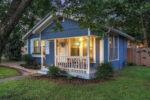 Einbungalow mit Veranda, Eingangstür und kleinem Garten.