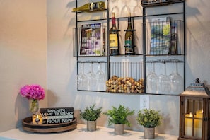 A wine tasting setup with bottles, corks, and a sign indicating a rescheduled event.