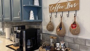 Una cocina con barra de café, una cafetera y un letrero que dice 'Coffee Bar'.