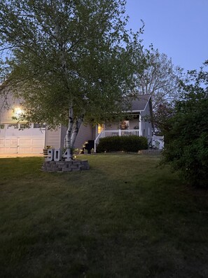 A residential house with a front yard, a mailbox, and a number '904' sign.