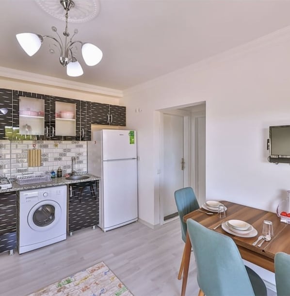 Enjoy self-catering facilities in this modern kitchen with a central island and dining area, featuring a dishwasher, refrigerator, and washing machine.